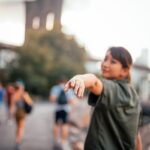 selective focus photograph of woman raising her hand